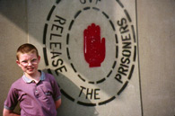 Boy in front of Release the Prisoners graffiti.